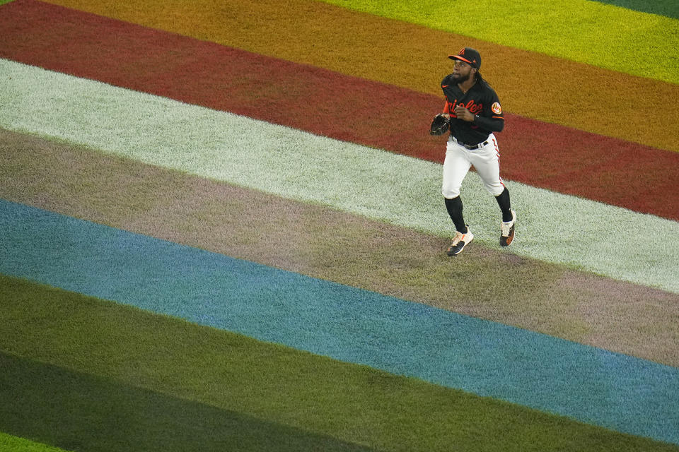 Baltimore Orioles center fielder Cedric Mullins walks over a painted flag in center field in honor of Pride Night in the sixth inning of a baseball game against the Cincinnati Reds, Wednesday, June 28, 2023, in Baltimore. (AP Photo/Julio Cortez)