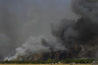 A helicopter of the Greek Fire Service flies during a wildfire that broke out in Tatoi, northern Athens, Greece, Tuesday, Aug. 3, 2021. The Greek Fire Service maintained an alert for most of the country Tuesday and Wednesday, while public and some private services shifted operating hours to allow for afternoon closures. (AP Photo/Michael Varaklas)