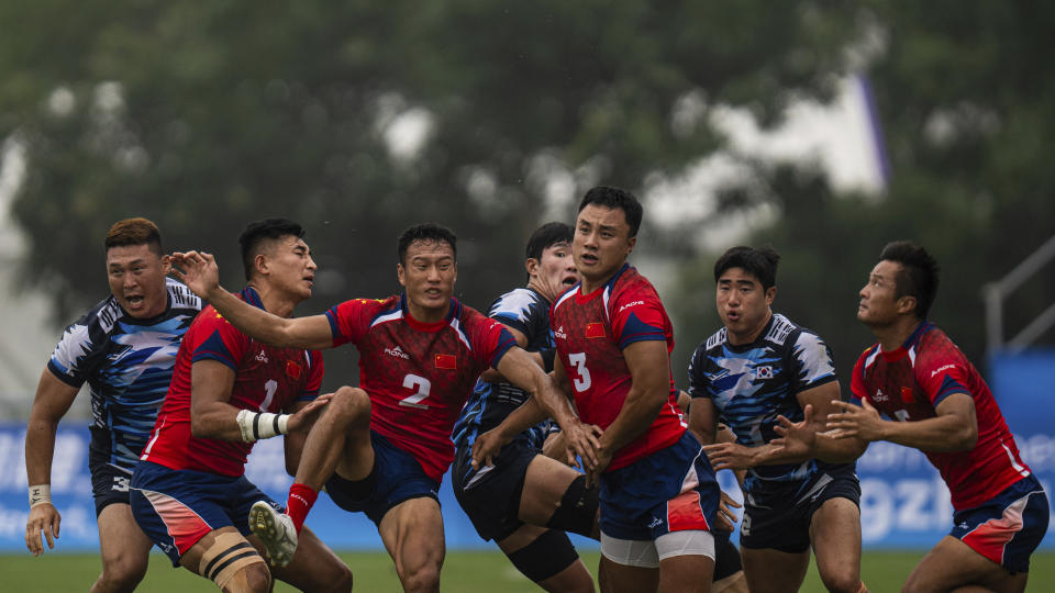 China's Li Benshou, center, tries to catch the ball during the men's semifinal Rugby Sevens match between China and South Korea at the 19th Asian Games in Hangzhou, China, Tuesday, Sept. 26, 2023. (AP Photo/Louise Delmotte)