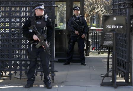 Armed police officers stand at the Carriage Gates entrance to the Houses of Parliament, following the attack in Westminster earlier in the week, in London, Britain March 25, 2017. REUTERS/Peter Nicholls