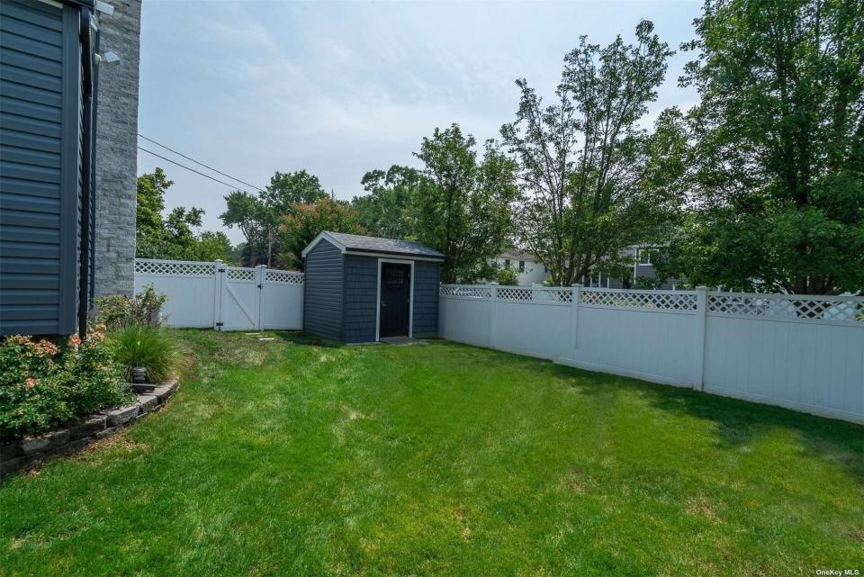 The backyard of a house on long island with grass and a small shed