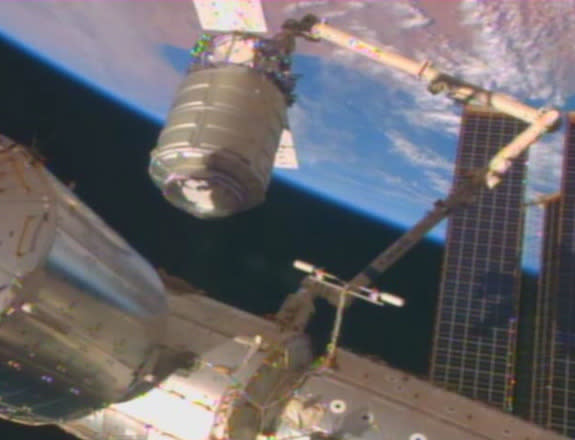 The Orb-1 Cygnus cargo ship built by Orbital Sciences Corp. of Dulles, Va., is seen at the end of a robotic arm with a dazzling view of Earth as the backdrop in this view from the International Space Station on Jan. 12, 2014. The commercial car