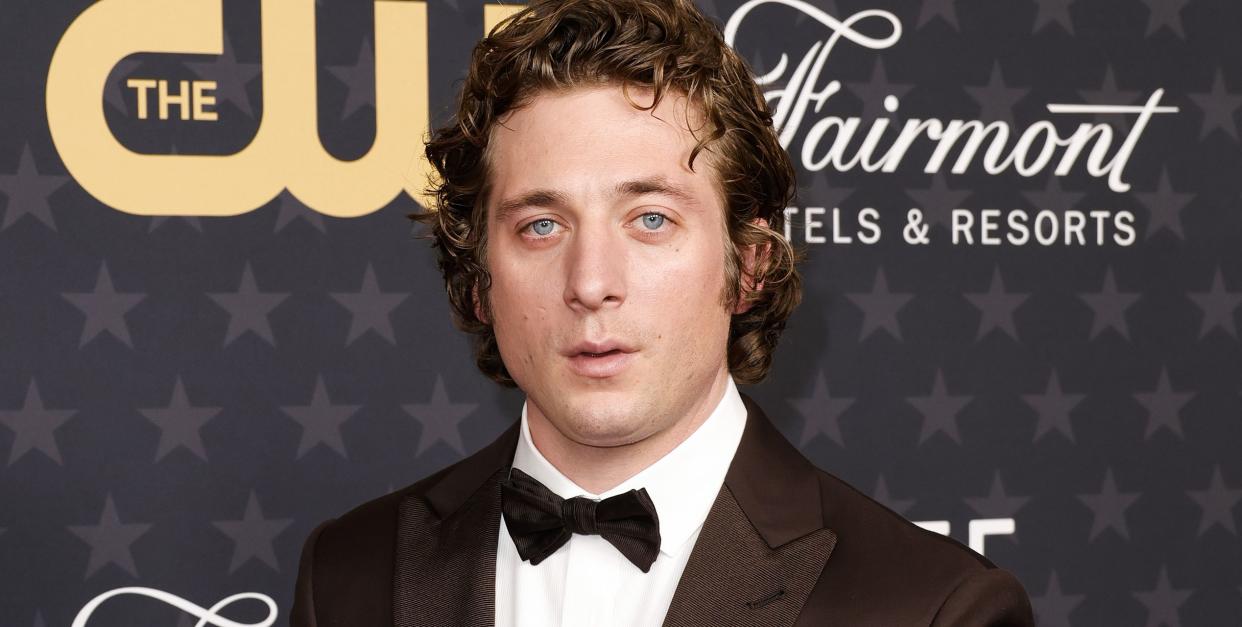 jeremy allen white posing on the red carpet in a black suit