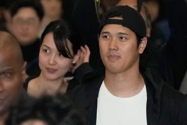 <p>Lee Jin-man/AP</p> Shohei Ohtani and Mamiko Tanaka walk with security during the Dodgers' arrival at Incheon International Airport on March 15, 2024 ahead of the team's baseball series against the San Diego Padres.
