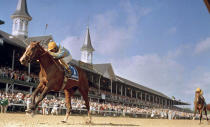 FILE - Unbridled with jockey Craig Perret in the irons, passes the landmark twin-spires at Churchill Downs on his way to winning the Kentucky Derby horse race, May 5, 1990, in Louisville, Ky. (AP Photo/Bob Daugherty, FIle)