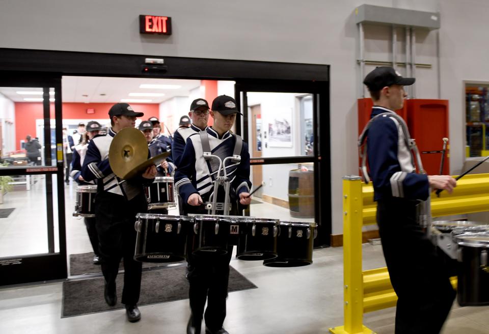 The Fairless High School marching band leads a crowd Wednesday inside the new Tractor Supply Co. warehouse at 3001 Sterilite St. SE, Navarre.