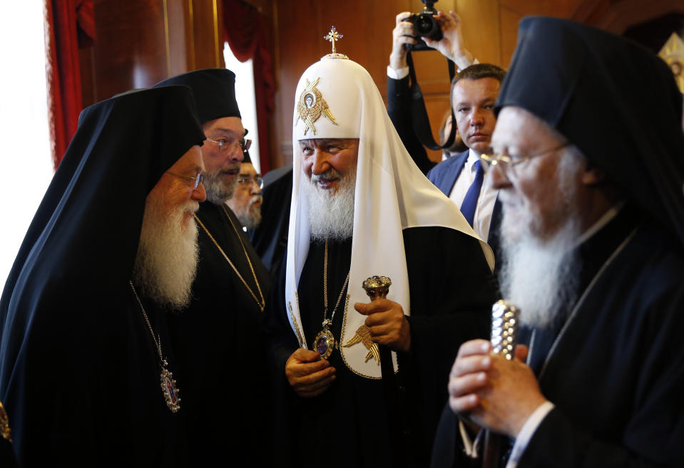 FILE - In this file photo taken on Friday, Aug. 31, 2018, Patriarch Kirill of Moscow, centre, is introduced to officials by Ecumenical Patriarch Bartholomew I, right, the spiritual leader of the world's Orthodox Christians, prior to their meeting at the Patriarchate in Istanbul. The Istanbul-based Ecumenical Patriarchate says it will move forward with its decision to grant Ukrainian clerics independence from the Russian Orthodox Church. The decision was announced Thursday, Oct. 11 following a regular holy synod meeting. (AP Photo/Lefteris Pitarakis, file)