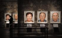 A man walks beside photos of the exhibition 'Survivors - Faces of Life after the Holocaust' at the former coal mine Zollverein in Essen, Germany, Tuesday, Jan. 21, 2020. The world heritage landmark Zollverein shows 75 years after the liberation of the Nazi death camp Auschwitz-Birkenau, 75 portraits of Jewish survivors, photographed in Israel by German artist Martin Schoeller. (AP Photo/Martin Meissner)