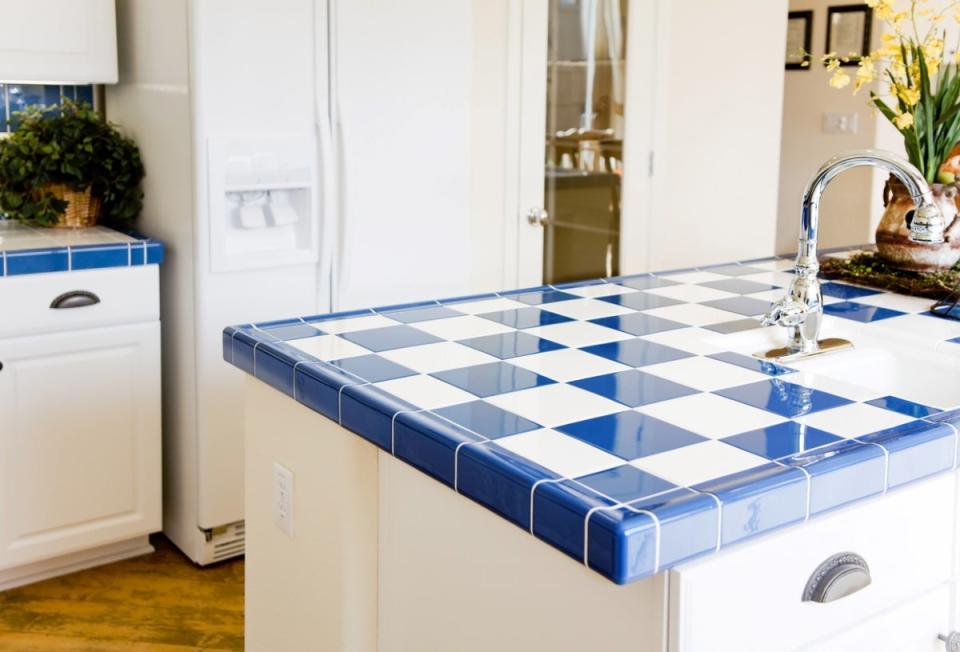 Checkered white and blue kitchen tile countertop in a circa 1990s kitchen.