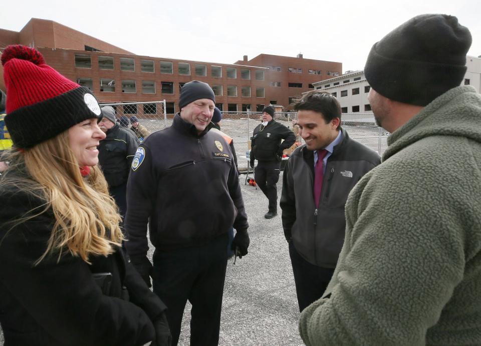 Ward 9 City Councilwoman Tina Boyes, left, and Akron Mayor Shammas Malik, second from right, talk with police officers at The Word Church, formerly the Akron Baptist Temple, after an onsite press conference on Tuesday. Akron police and firefighters were checking the dilapidated building to make sure it was empty before demolition started.