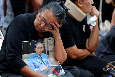 A woman holds a portrait of Thailand's late King Bhumibol Adulyadej at the Siriraj hospital in Bangkok, Thailand, October 14, 2016. REUTERS/Chaiwat Subprasom