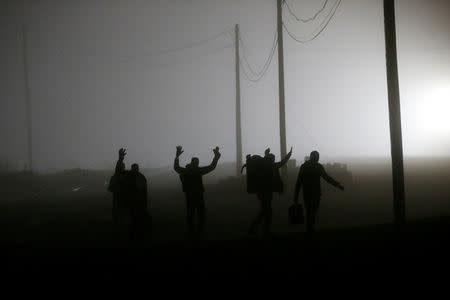 A group of migrants who said they were from Djibouti and Somalia follow railway tracks towards the Canada-U.S. border as seen from Emerson, Manitoba, Canada, March 27, 2017. REUTERS/Chris Wattie