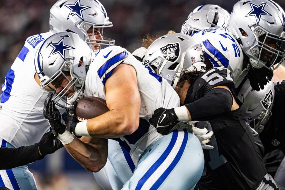 Dallas Cowboys running back Hunter Luepke (43) gets wrapped up by Las Vegas Raiders defenders in the first half of a preseason game at AT&T Stadium in Arlington, Texas on Saturday, Aug. 26, 2023.