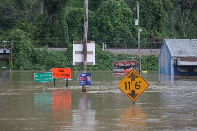 Road signs are barely visible on a road covered by floodwaters from the North Fork of the Kentucky River in Jackson, Kentucky, on July 28. (Photo: LEANDRO LOZADA/AFP/Getty Images)