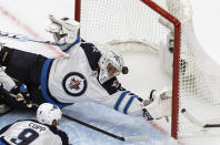 Winnipeg Jets goalie Connor Hellebuyck (37) is scored on by Calgary Flames' Johnny Gaudreau as Jets' Andrew Copp defends during the second period of an NHL hockey playoff game Saturday, Aug. 1, 2020 in Edmonton, Alberta. (Jason Franson/The Canadian Press via AP)