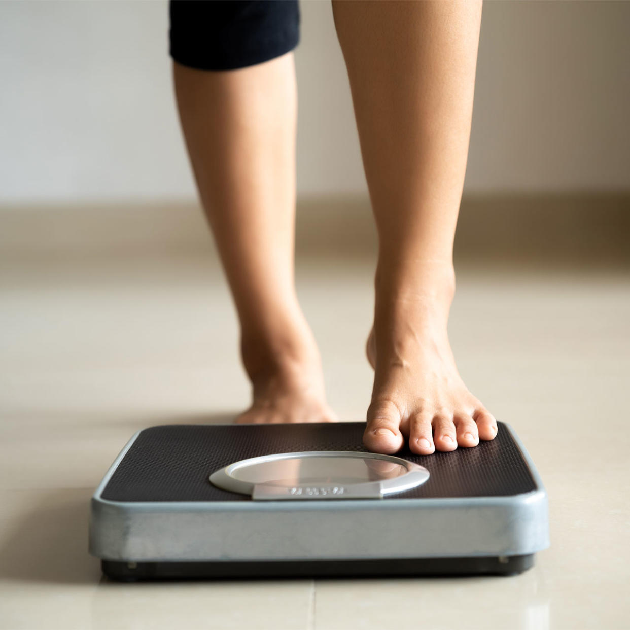 woman stepping onto a scale