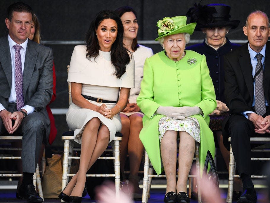 Meghan Markle sitting in a "duchess slant" with Queen Elizabeth