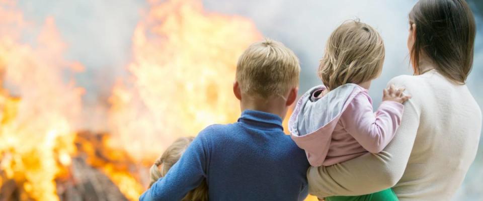 Family mother with children at burning house fire accident background