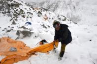 Pasang Sherpa searches through flattened tents in search of survivors after an avalanche that flattened parts of Everest Base Camp, on April 25, 2015