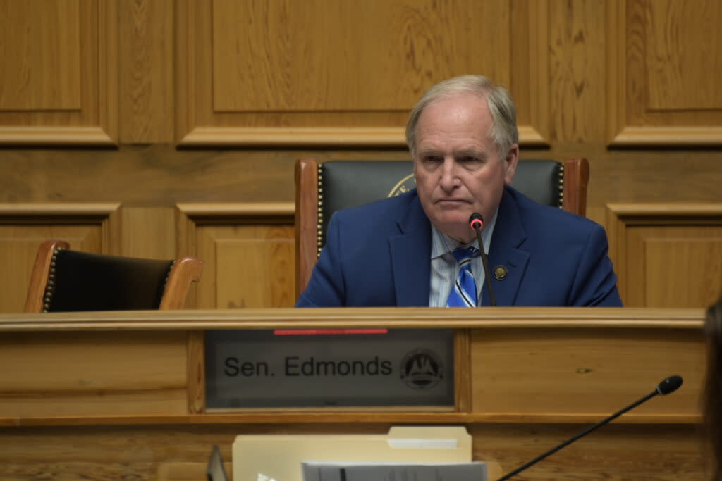 Sen. Edmonds sits at a desk with his name on it.