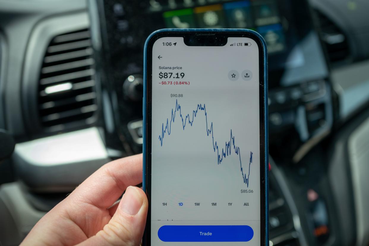 Person's hand holding an iPhone displaying chart of the price of Solana cryptocurrency, Lafayette, California, May 2, 2022.