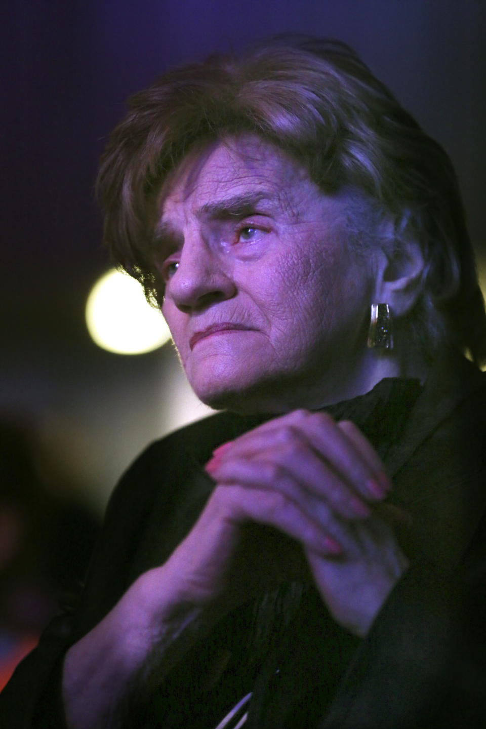 Charlotte Cukier, 90, watches Orthodox Jewish singer Yaakov Shwekey perform at a concert honoring her and dozens of other Holocaust survivors on Monday, June 14, 2021, at the Yeshivah of Flatbush theater in the Brooklyn borough of New York. It was the first large gathering of Holocaust survivors after more than a year of isolation due to the coronavirus pandemic. (AP Photo/Jessie Wardarski)