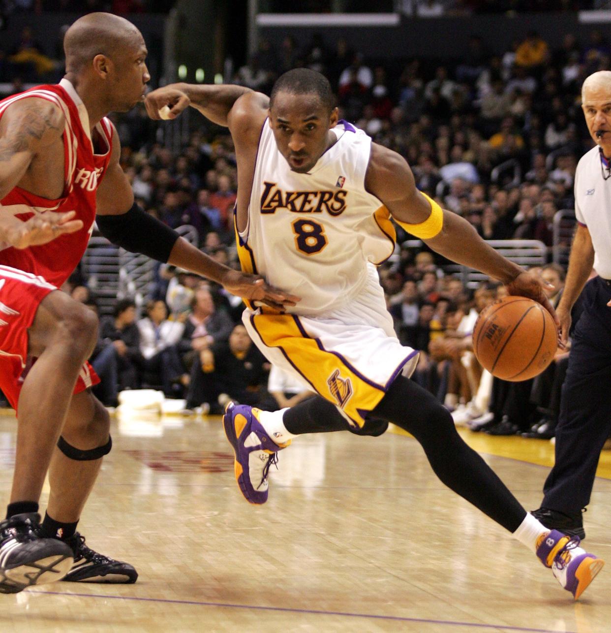 Los Angeles Lakers' Kobe Bryant (8) drives around the defense of Houston Rockets' Stromile Swift, left, during the fourth quarter of NBA basketball action, Sunday, Dec. 18, 2005, in Los Angeles. The Rockets won 76-74.