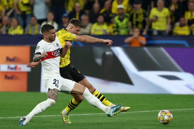 Le défenseur du PSG Lucas Hernandez (g) se blesse au genou gauche lors d'un choc avec l'attaquant de Dortmund Niclas Füllkrug (d) qui marque sur l'action, le 1er mai 2024 à Dortmund (FRANCK FIFE)