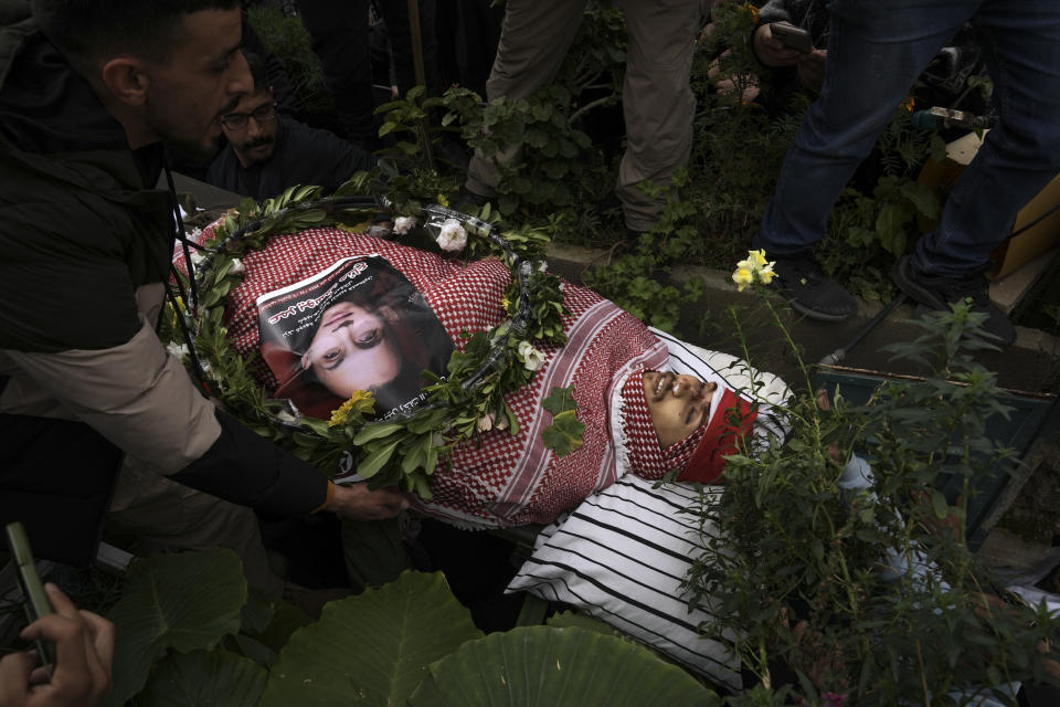 Palestinian mourners carry the body of Omar Manaa during his funeral in the West Bank refugee camp of Deheishe near Bethlehem, Monday, Dec. 5, 2022. Palestinian health officials say Manaa, 22-year-old Palestinian man, was killed by Israeli fire during a military raid in the occupied West Bank. The army said it opened fire after a crowd attacked soldiers with stones and firebombs. (AP Photo/Mahmoud Illean)