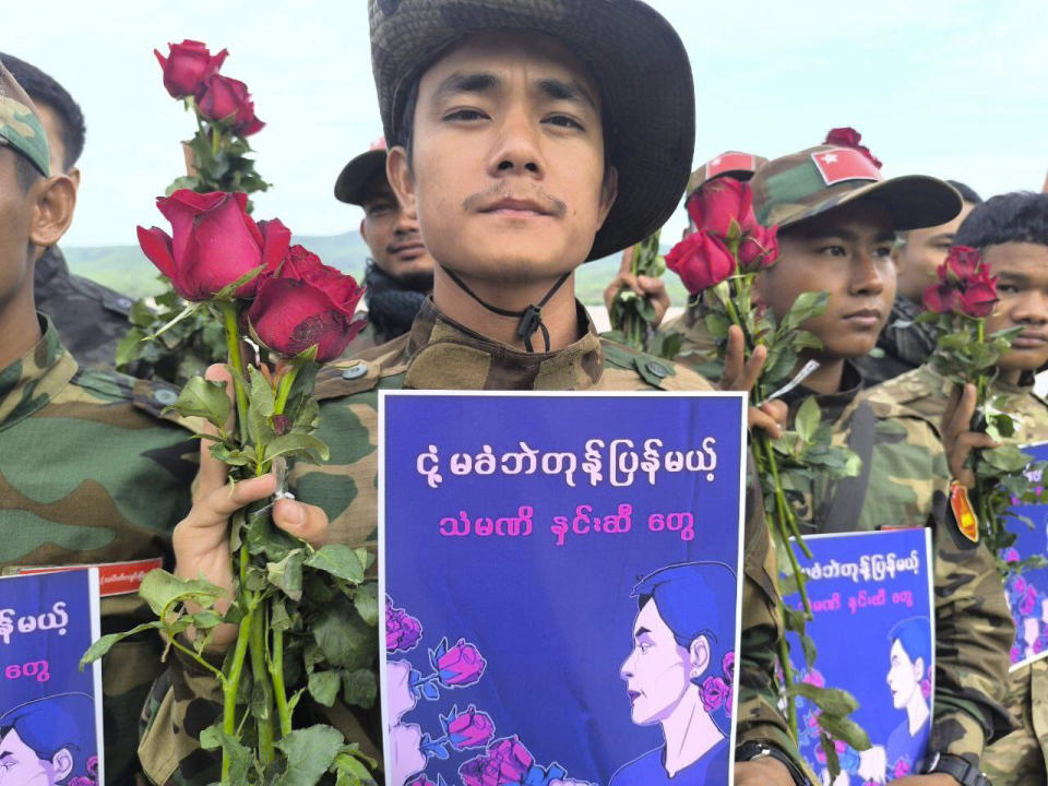 In this photo provided by Thabeikkyin Township People’s Defense Force, the group's members pose for photographs with the roses and posters that read ''The steel roses will retaliate against the junta’s oppression without yielding,'' as they celebrate the 79th birthday of the country’s ousted leader Aung San Suu Kyi in Thabeikkyin township in Mandalay region, Myanmar on Wednesday, June 19, 2024. ( Thabeikkyin Township People’s Defense Force via AP)