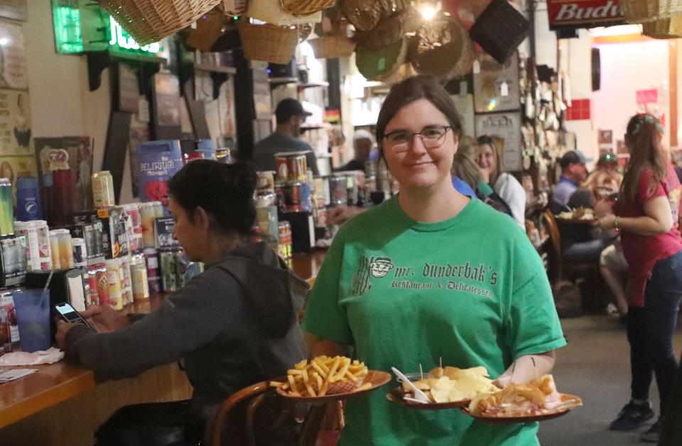 Brandi Parks, a longtime manager and server at Mr. Dunderbak's Bavarian Restaurant & Delicatessen at Volusia Mall in Daytona Beach, brings out an order for customers on Friday, Dec. 16, 2022.