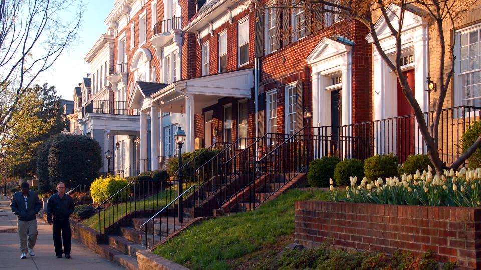 Richmond, VA, USA April 4, 2006 Two adult men walk past the historic homes on Monument Avenue in Richmond, Virginia.