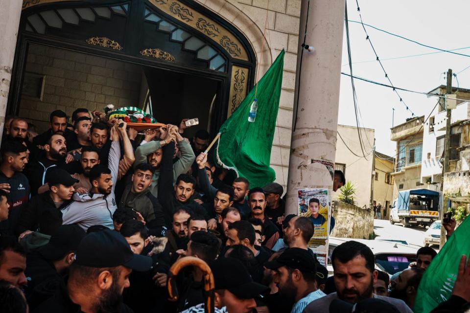 Community members and relatives carry the body of Amro Najjar, 10, out of a building.