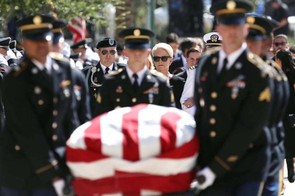 Cindy McCain walks behind her late husband's casket as it is carried into the Arizona State Capitol