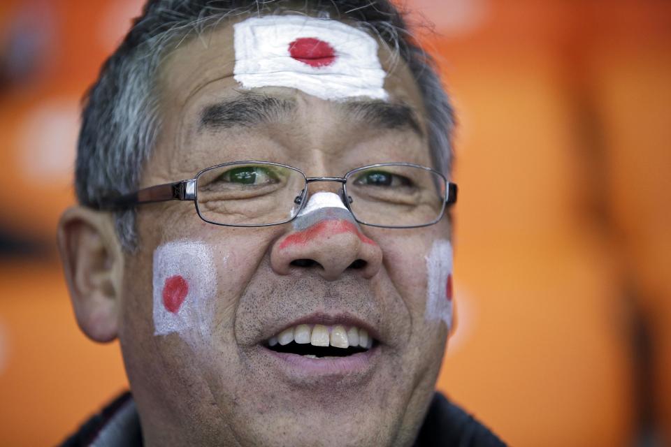 A Japanese skating fan, face painted with colors of his national flag, waits for the start of the men's 1000-meter speedskating race at the Adler Arena Skating Center at the 2014 Winter Olympics, Wednesday, Feb. 12, 2014, in Sochi, Russia. (AP Photo/David J. Phillip )