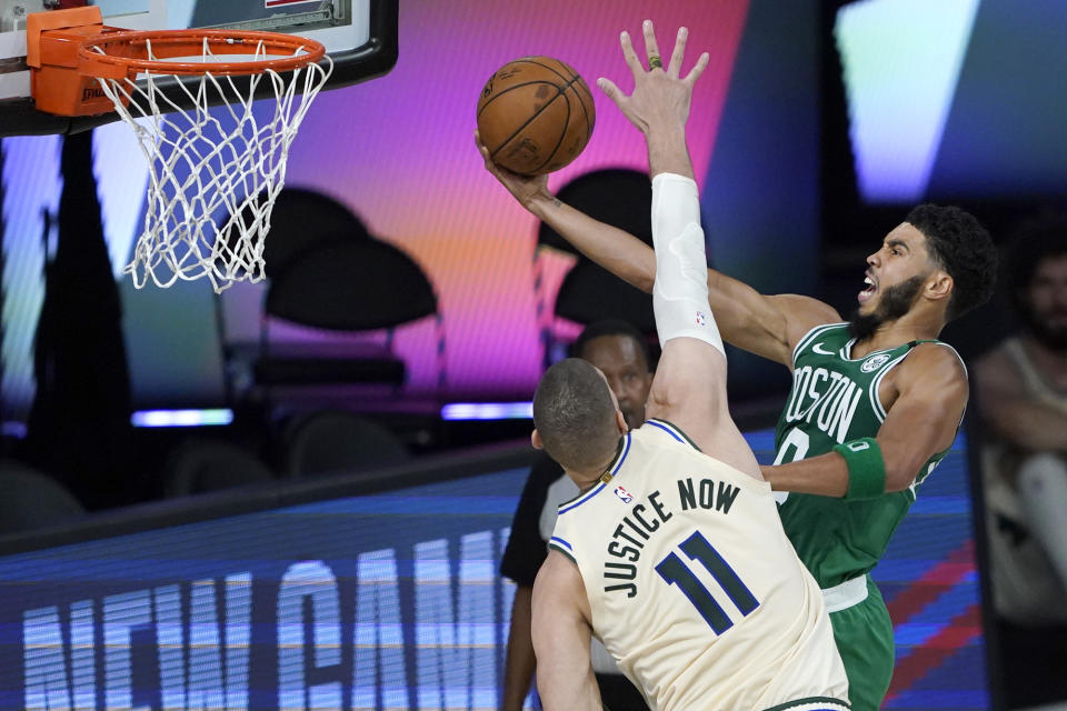 Boston Celtics' Jayson Tatum, right, heads to the basket as Milwaukee Bucks' Brook Lopez (11) defends during the first half of an NBA basketball game Friday, July 31, 2020, in Lake Buena Vista, Fla. (AP Photo/Ashley Landis, Pool)