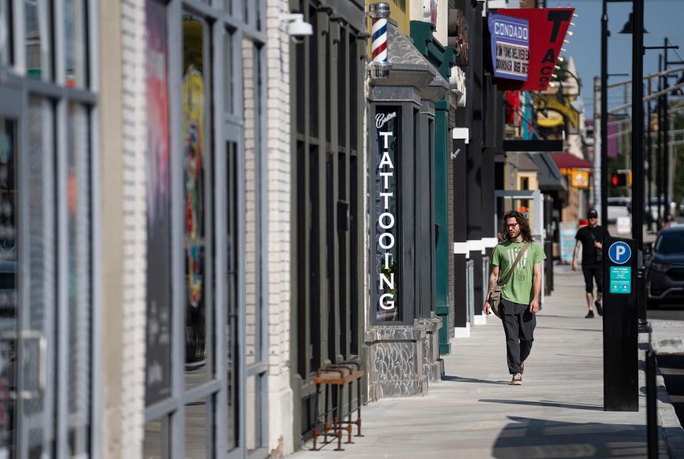 A pedestrian walks along the 800 block of Broad Ripple Avenue on Tuesday, Sept. 19, 2023, in Indianapolis.