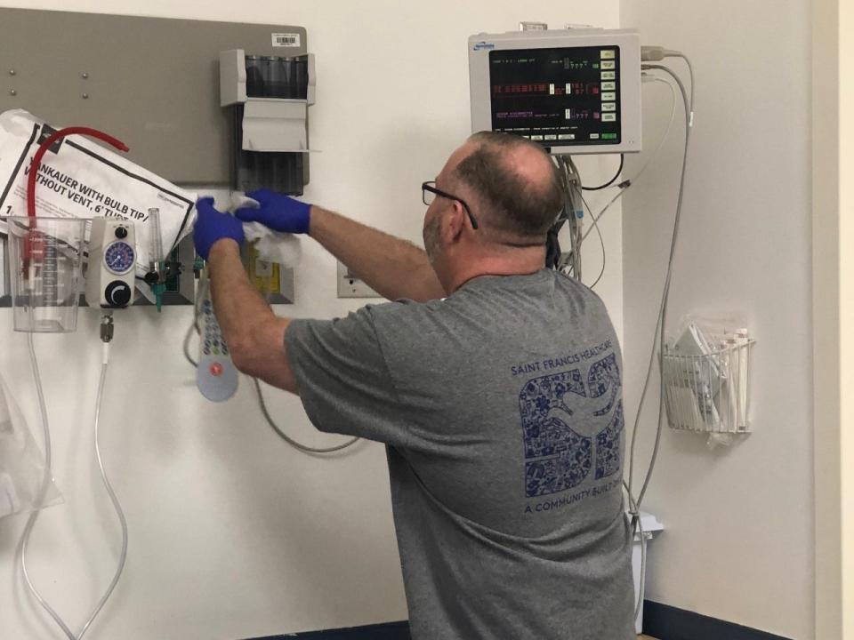Emergency department nurse Cary Hamilton cleans an examination room in preparation for a new patient at Saint Francis Hospital-Bartlett on Feb. 14, 2023.