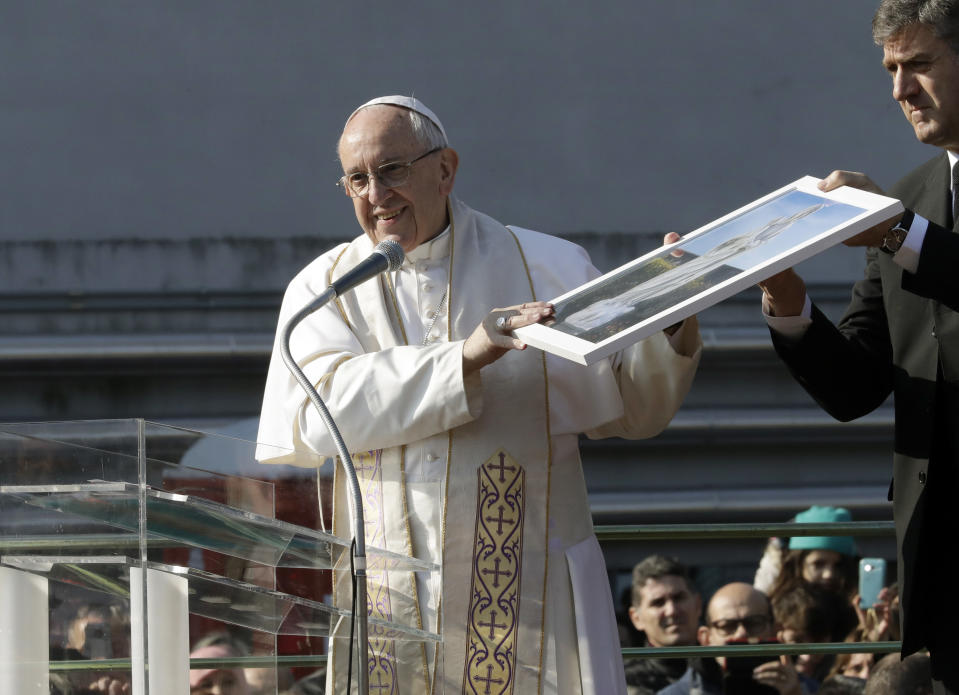 Pope Francis shows a framed image of the Madonna during his visit at Milan's Forlanini neighborhood known as Case Bianche (white houses), as part of his one-day pastoral visit to Monza and Milan, Italy’s second-largest city, Saturday, March 25, 2017. The pope's first stop Saturday is a housing project on the outskirts of Italy's fashion and finance capital, a stop that underlines the pope's view that the peripheries offer a better view of reality than well-tended and prosperous city centers. (AP Photo/Antonio Calanni)