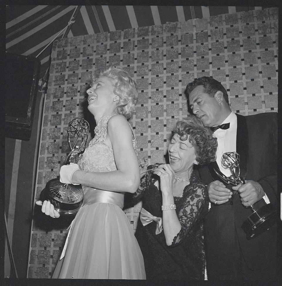 <p>Newly minted Emmy-winner Barbara Stanwyck has the back of her gown sewn after ripping it as she left her seat to collect her award for Outstanding Lead Actress. </p>