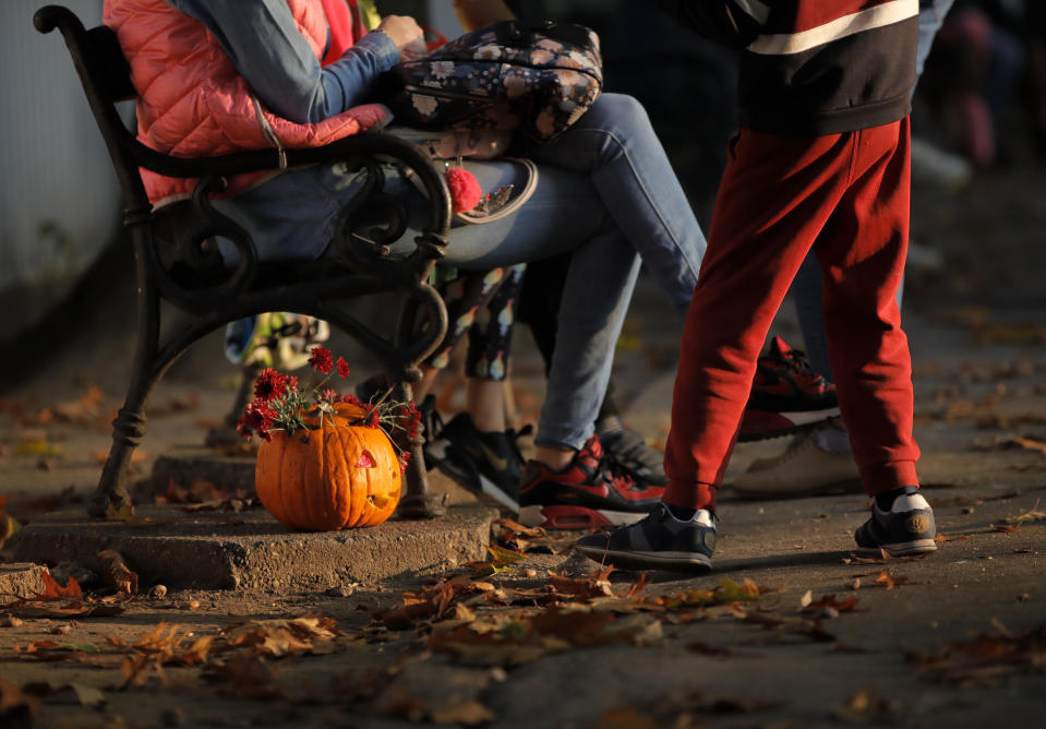 In this Saturday, Oct. 26, 2019 photo a carved Halloween pumpkin is placed next to a bench at The Halloween Pumpkin Fest in Bucharest, Romania. (AP Photo/Vadim Ghirda)