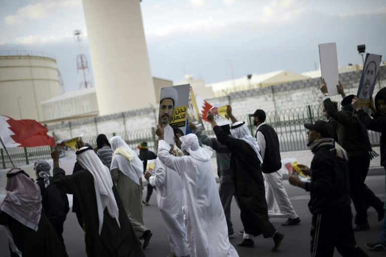 Protestors hold placards depicting portraits of Sheikh Ali Salman, head of the Shiite opposition movement al-Wefaq, during clashes with police after Salman's arrest in the village of Sitra on January 29, 2016