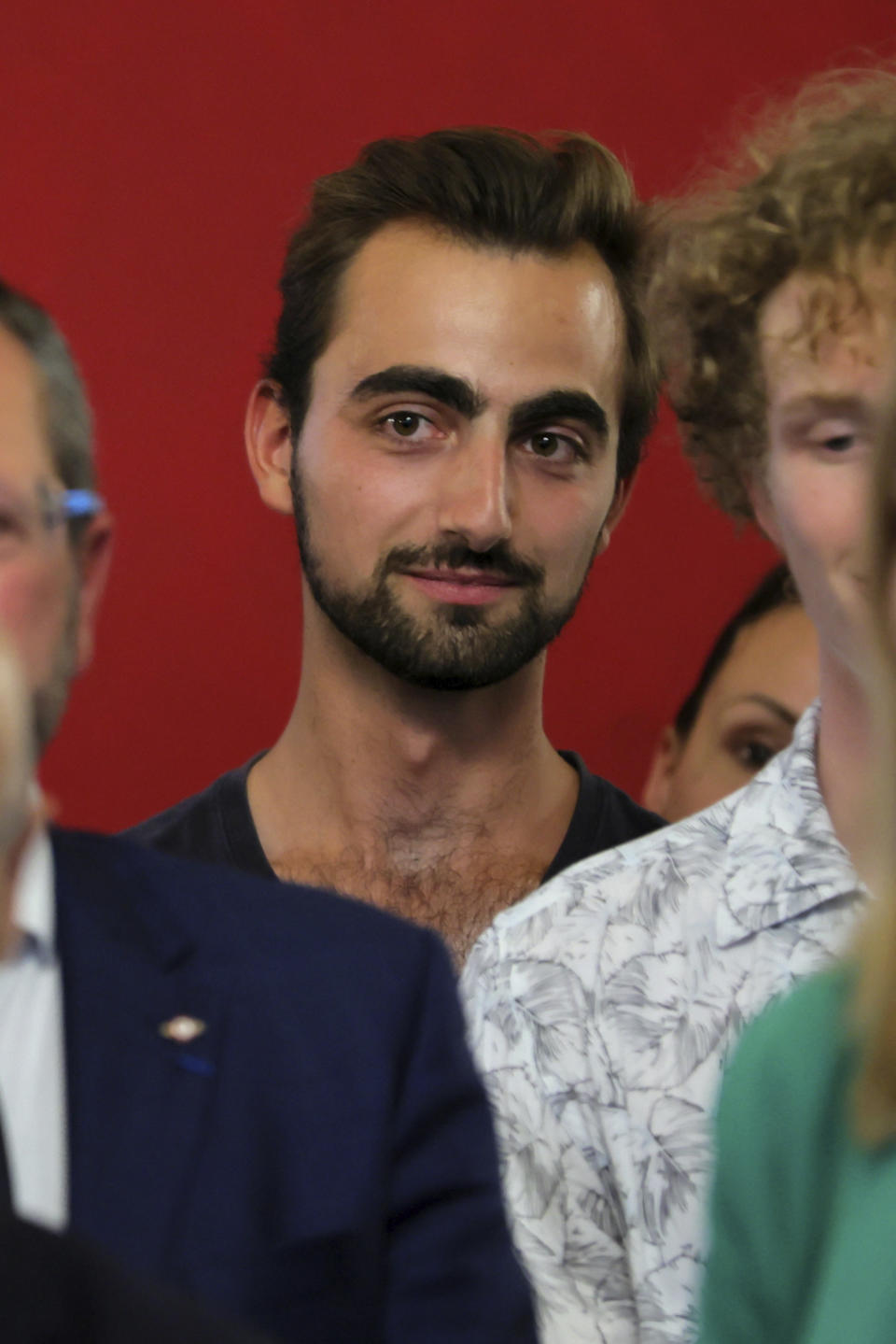 Henri, listens to French President Emmanuel Macron delivering a speech as he meets rescue forces in Annecy, French Alps, Friday, June 9, 2023. The 24-year-old man in France is being hailed as a hero after he intervened in a savage knife attack on very young children. Henri had a heavy backpack on his back and was holding another in his hand when the attacker slashed at him Thursday June 8, 2023. Henri was shown grappling with the assailant and charging after him during the knife attack that critically wounded four children between the ages of 22 months and 3 years old, and also injured two adults. (Denis Balibouse/Pool via AP)