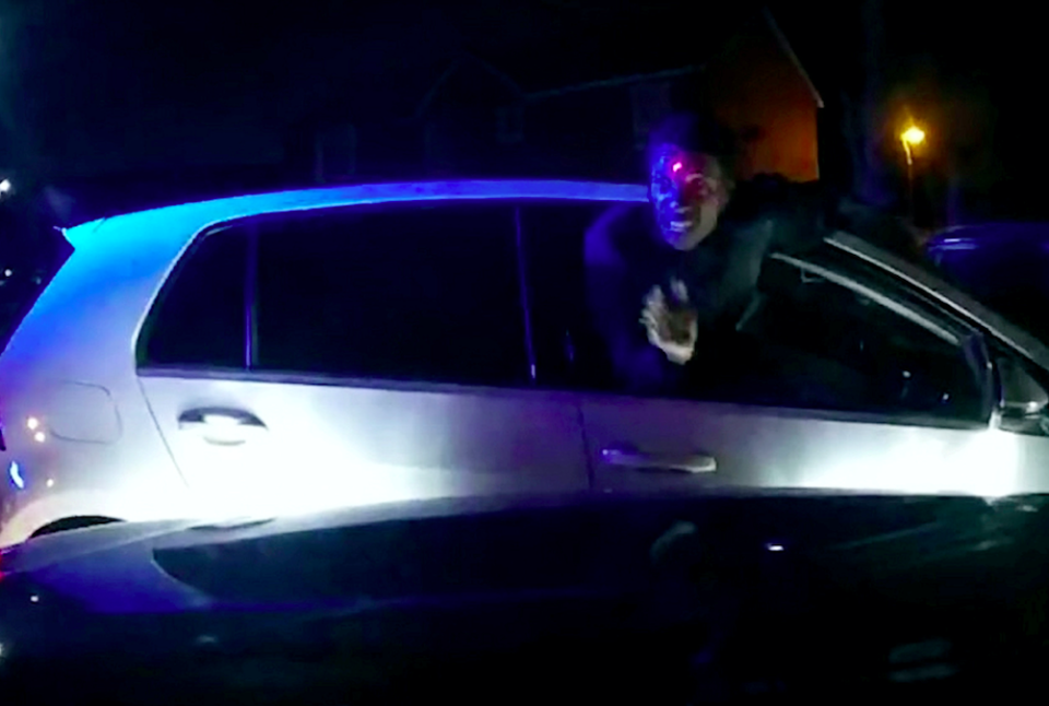 Justin Seymour is seen leaning out of the car window with a red taser laser dot trained on his forehead. (SWNS)