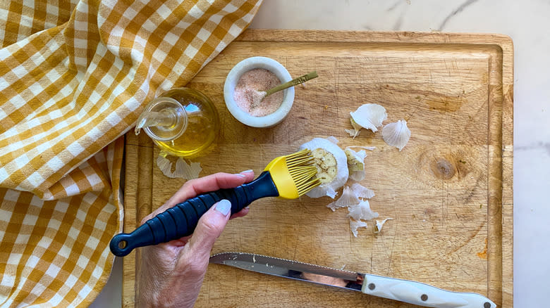 brushing oil on garlic
