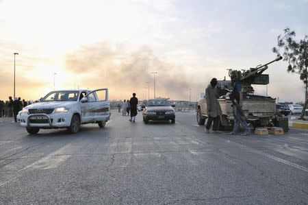 Fighters of the Islamic State of Iraq and the Levant (ISIL) stand guard at a checkpoint in the northern Iraq city of Mosul, in this June 11, 2014 file photo. REUTERS/Stringer