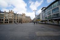 Few members of the public are seen near midday in an extremely quiet central Manchester