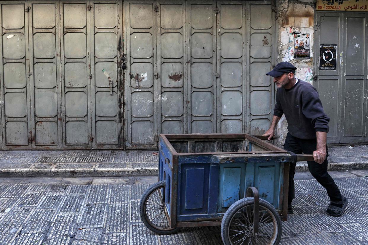 A man pushes an empty cart in Nablus, West Bank, following calls for a general strike in support of Palestinians in Gaza (AFP via Getty Images)