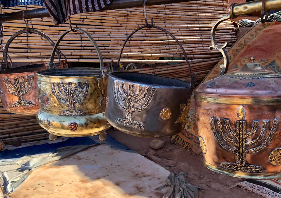 This Jan. 16, 2019, photo shows cooking pots adorned with menorahs in an outdoor stall near Ksar of Ait-Ben-Haddou in southern Morocco. The North African kingdom once had a thriving Jewish population. Jews of Moroccan descent return often in heritage tours. (Leanne Italie via AP)