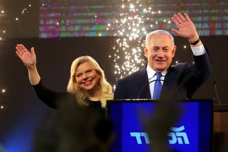 FILE PHOTO: Israeli Prime Minister Benjamin Netanyahu and his wife Sara wave as Netanyahu speaks following the announcement of exit polls in Israel's parliamentary election at the party headquarters in Tel Aviv, Israel